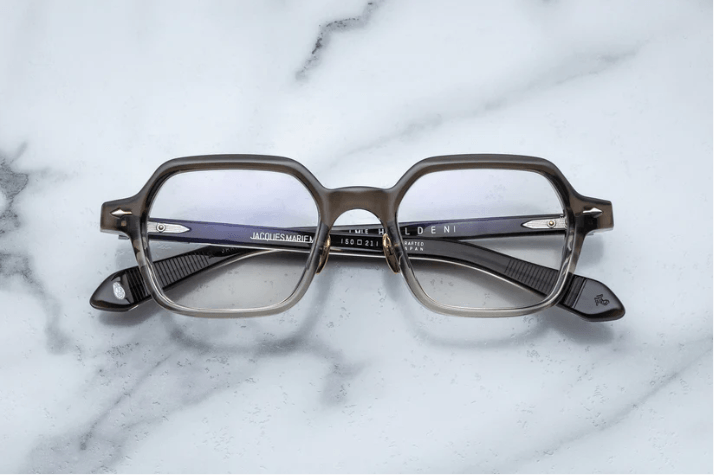 Jaques Marie Mage's Holden Smoke Fade RX design eyewear is on the marble table.